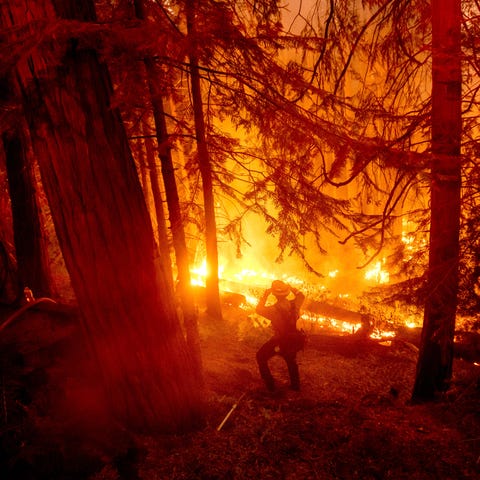 A firefighter battles the Creek Fire in the Shaver