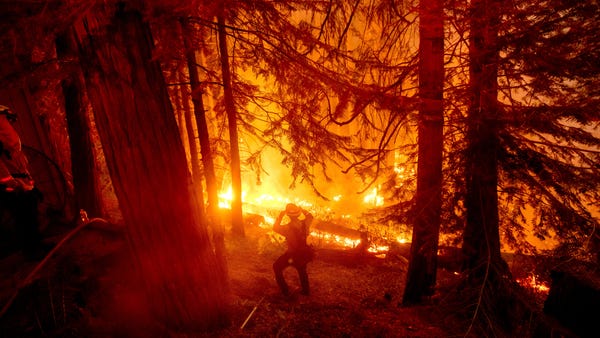 A firefighter battles the Creek Fire in the Shaver