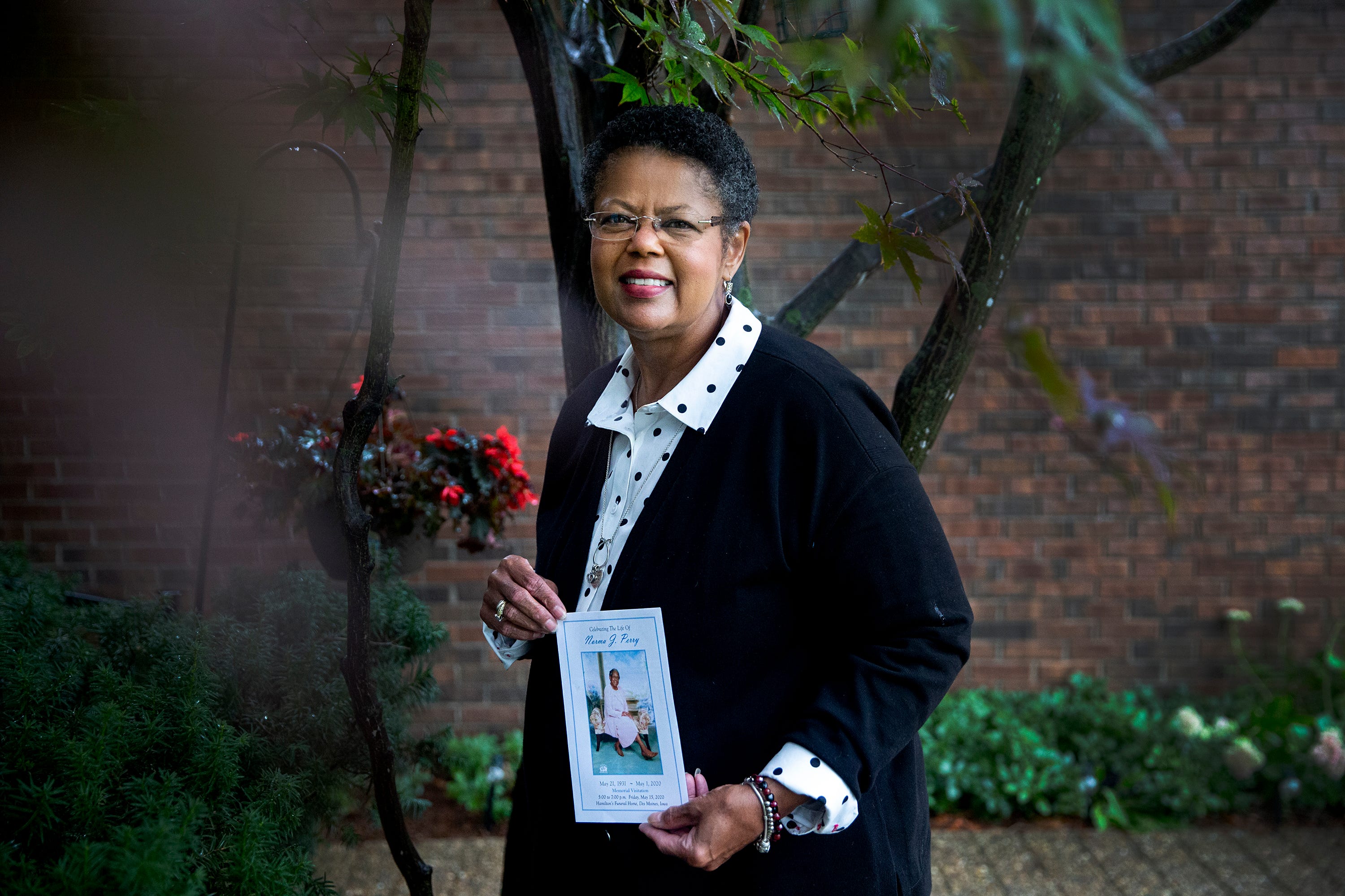 Deb Brewer Cotlar poses for a photo with a portrait of her aunt, Norma Jean Perry, who died from COVID-19.