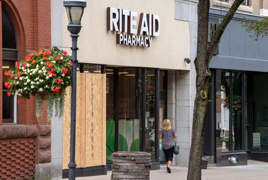 The Rite Aid in York with wood over two broken windows smashed by a man using a skateboard after he ransacked the inside of the store and attacking a shift manager.
