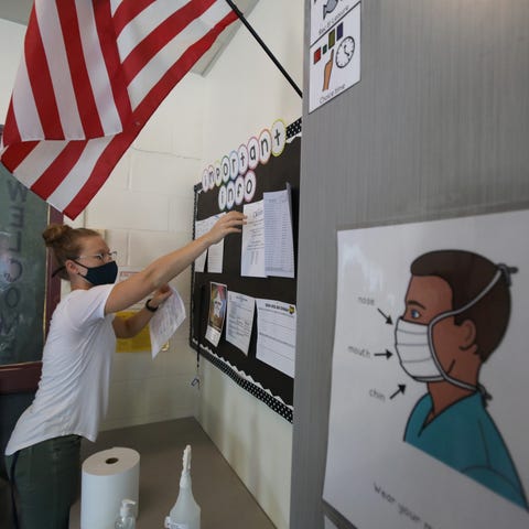 Teacher Emily Shaw sets up a bulletin board in her
