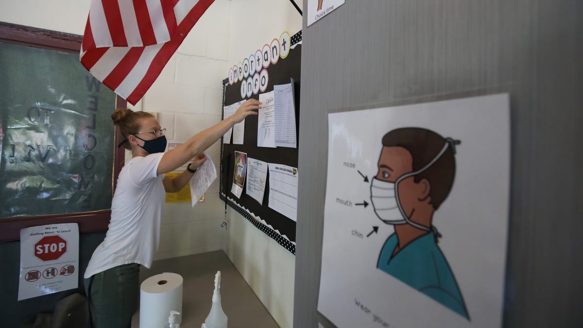 Teacher Emily Shaw sets up a bulletin board in her transition classroom at Creekside School in Fairport Wednesday, Sept. 9, 2020. The classroom has visual signs everywhere reminding students to wear a mask, and social distance. 