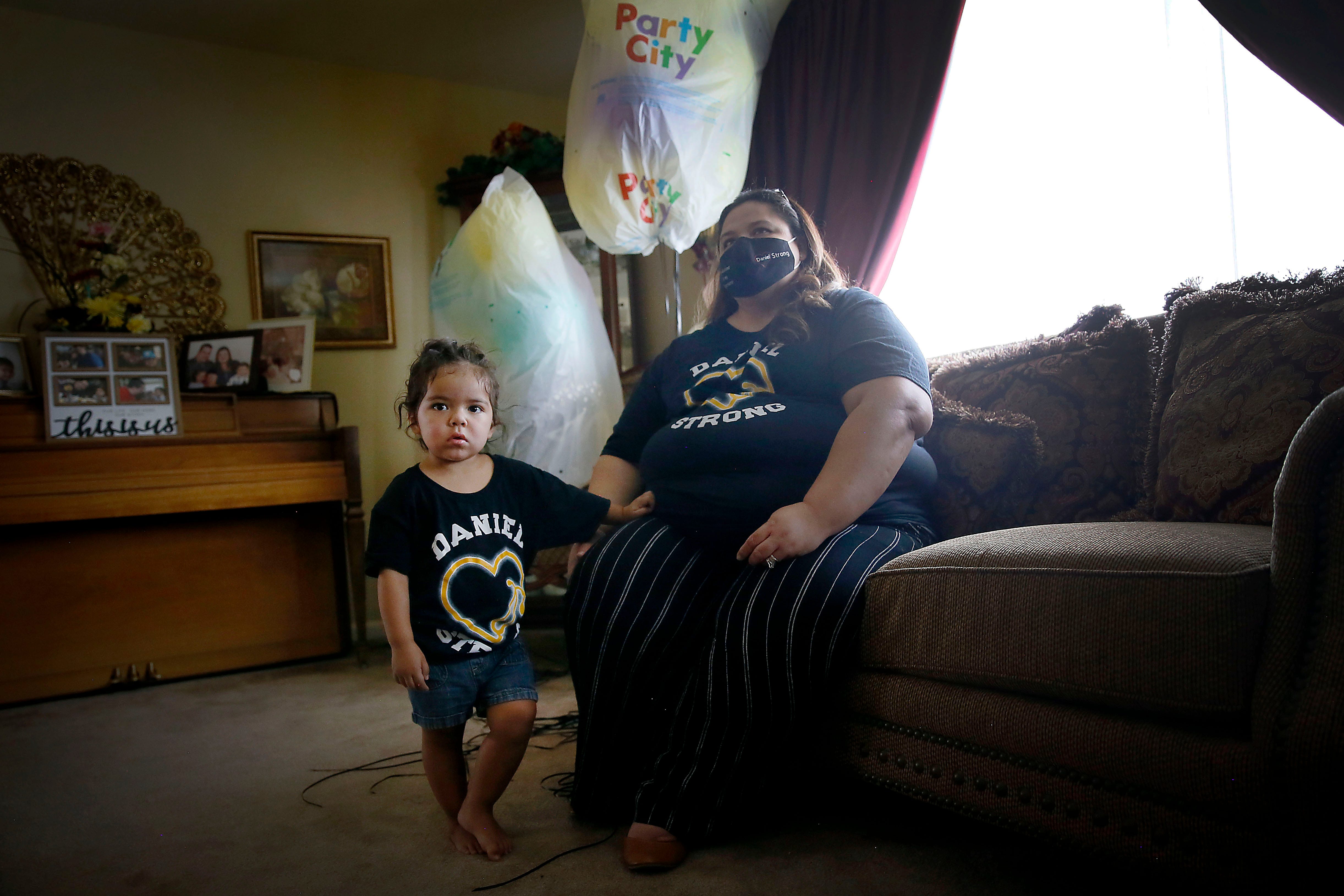 Erika Castor-Morales talks about her late husband, Daniel Morales, while holding her daughter, Desiree Morales, among balloons for what would have been his 40th birthday Aug. 21, 2020 at her in-laws' home in El Paso.