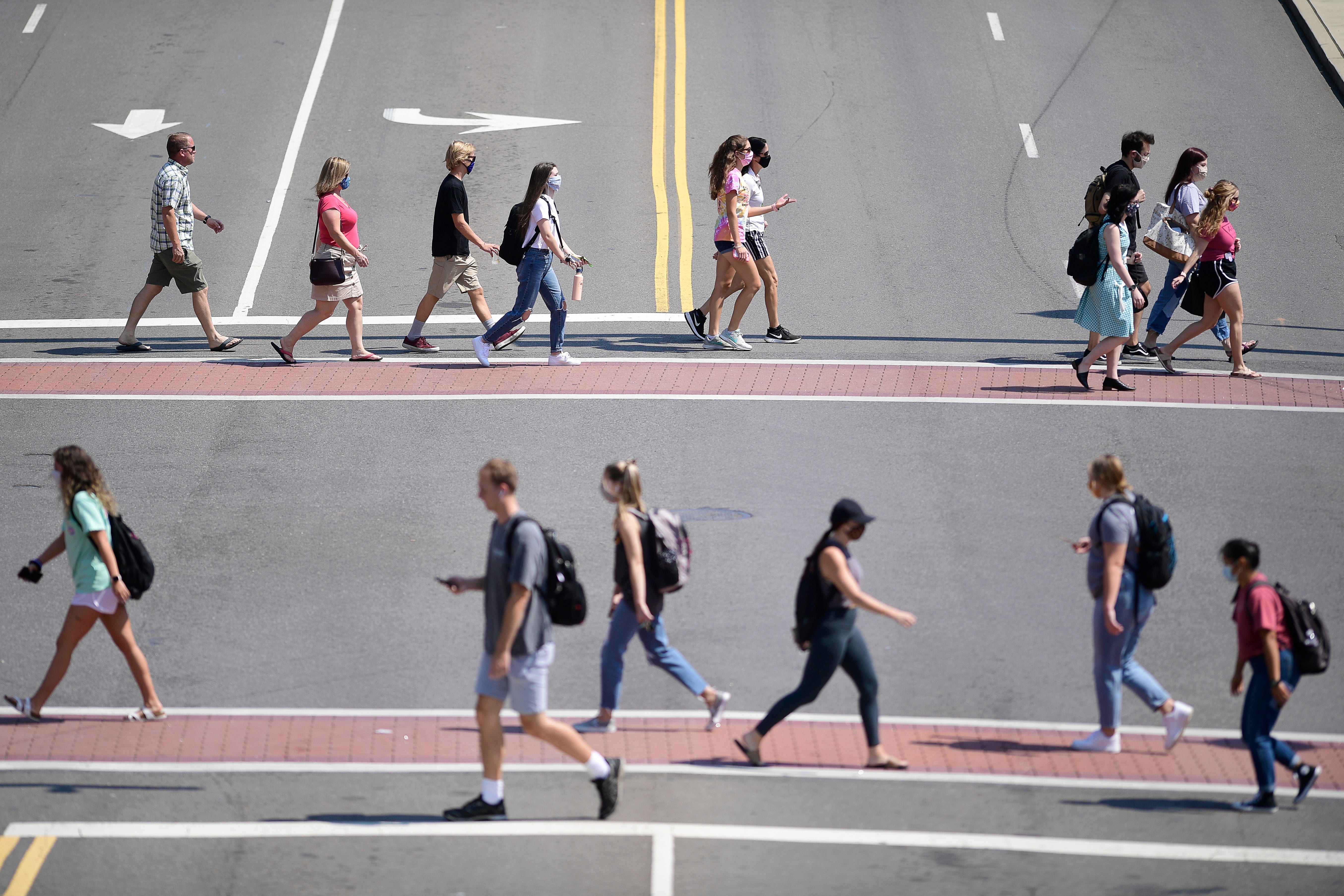 Life returned to college campuses as students cross Cumberland Avenue and Volunteer Boulevard at the University of Tennessee in Knoxville on Sept. 8.