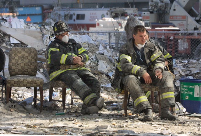 Emergency personnel catch a break during the cleanup operation at the World Trade Center after the towers were demolished by a terrorist attack on September 11, 2001.