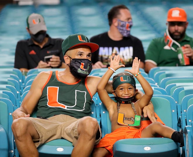 Armando Espinoza and his son Armando 3, of Belle Glade, watch as the University of Miami hosts the UAB Blazers at Hard Rock Stadium.