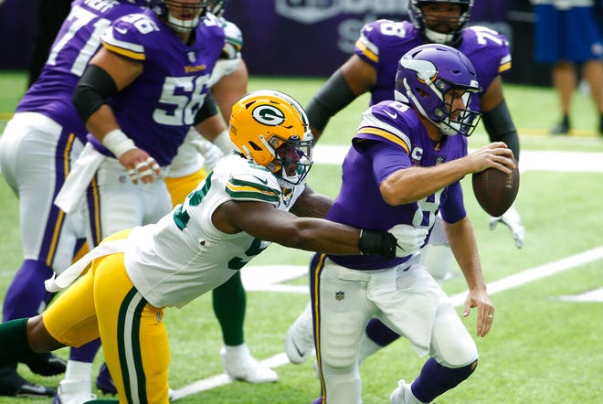 Minnesota Vikings quarterback Kirk Cousins (8) runs from Green Bay Packers linebacker Rashan Gary, left, during the first half of an NFL football game, Sunday, Sept. 13, 2020, in Minneapolis.