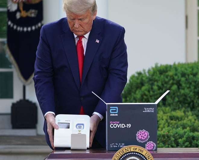 President Donald Trump holds a 5-minute test for Covid-19 from Abbott Laboratories on March 30, 2020, at the White House in Washington, DC.