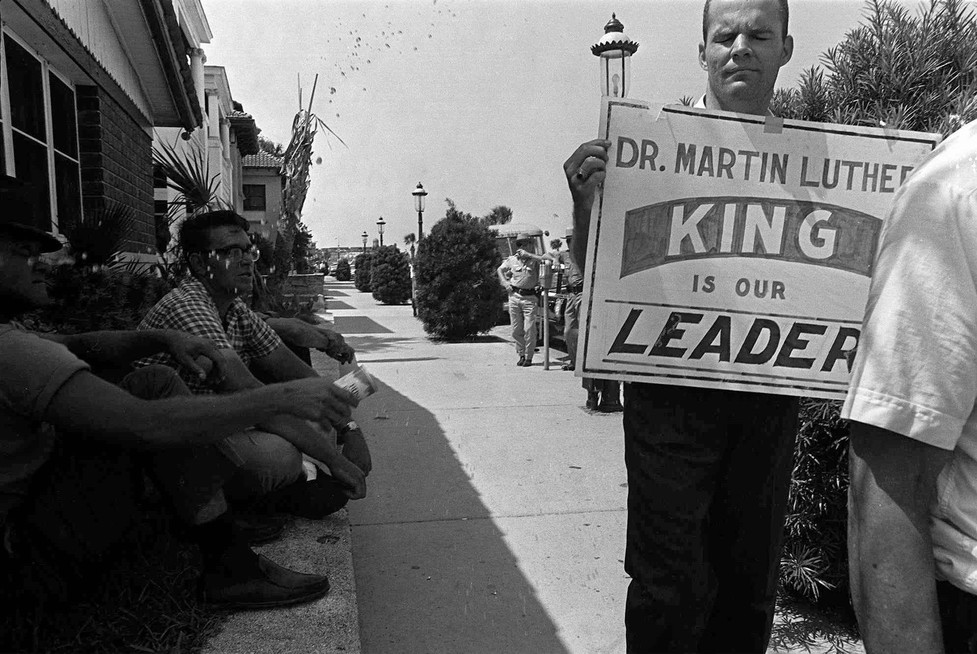 Demonstrator Charles Lingo, right, gets sprayed with beer from a man sitting against a wall, left, as a group of Black and white protesters marched through the streets of St. Augustine in June 1964. It was a bitter time in St. Augustine in the turbulent early 1960s with  the Ku Klux Klan attacking Black marchers and police using vicious tactics  against civil rights protesters.