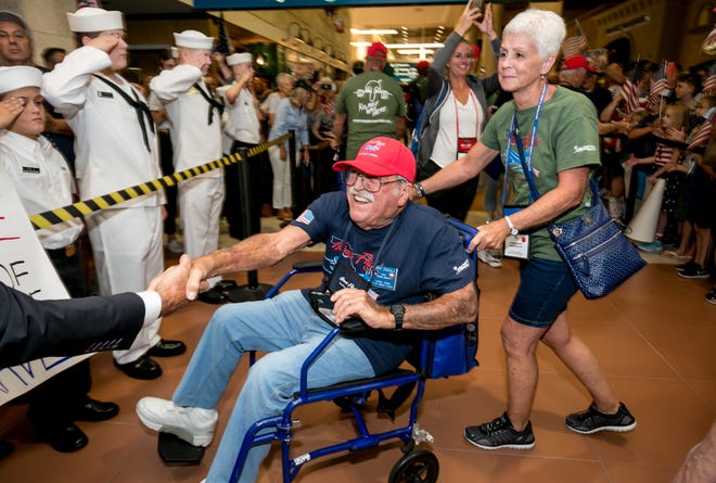 Boy scouts and cub scouts chant "U.S.A" during the arrival of veterans on a Southeast Florida Honor Flight at Palm Beach International Airport in this 2019 photo.
