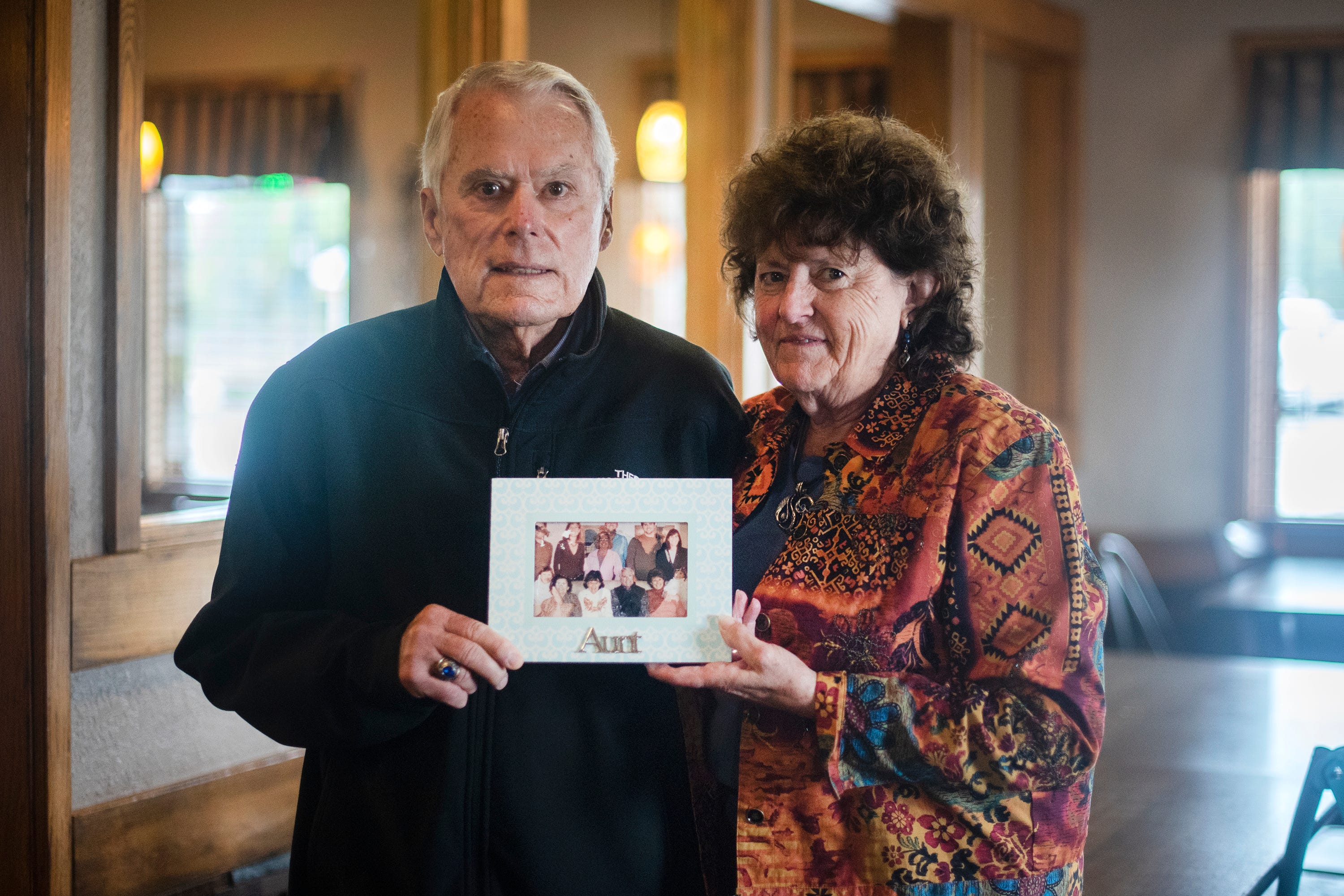 Walt Bussey and his wife, Cindy, hold a portrait of Walt's aunt Katie Jacobs, who died of COVID-19.