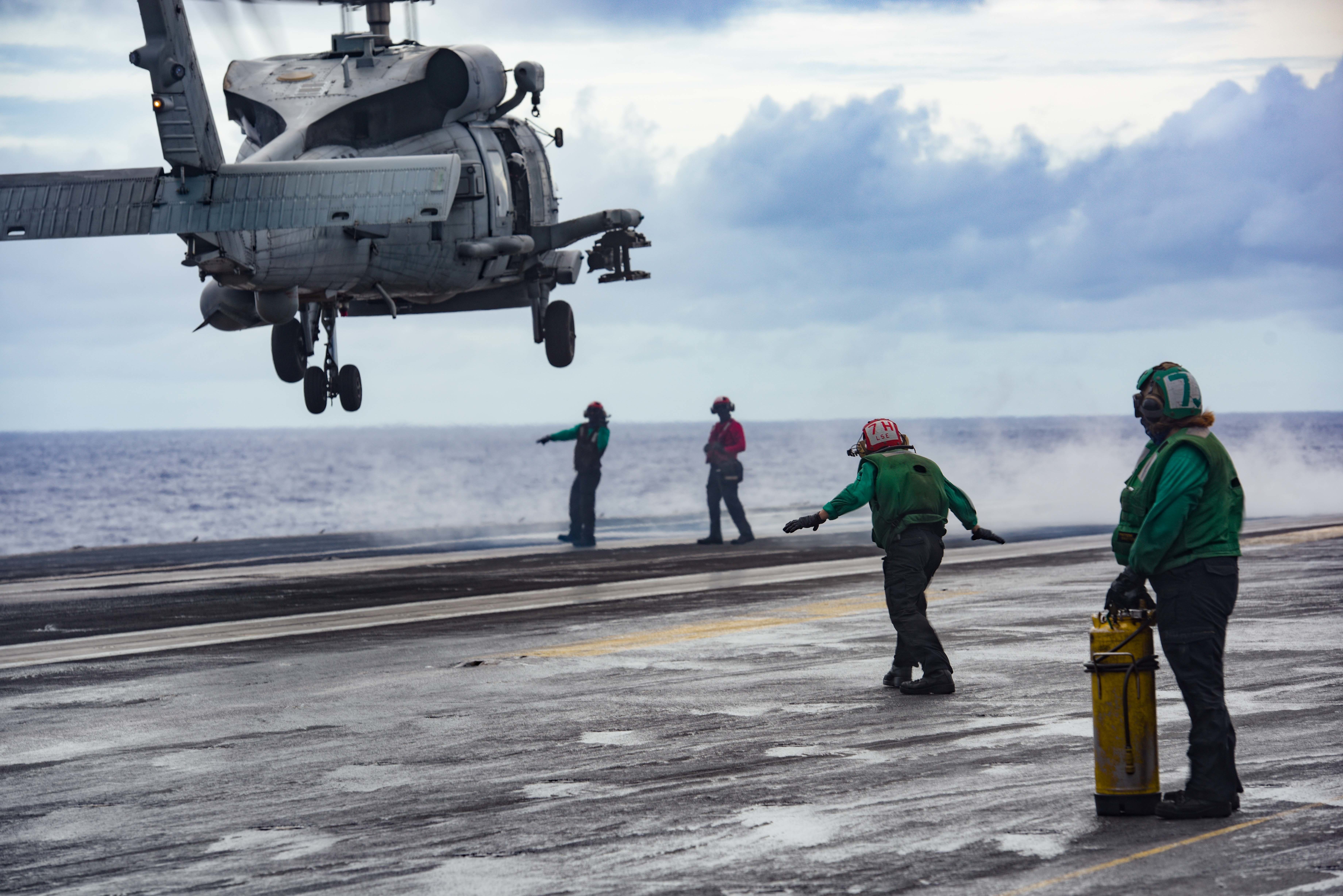 Sailors signal an MH-60R Sea Hawk attached to the Saberhawks of Helicopter Maritime Strike Squadron 77 to land on the flight deck of the aircraft carrier USS Ronald Reagan in support of Valiant Shield 2020.