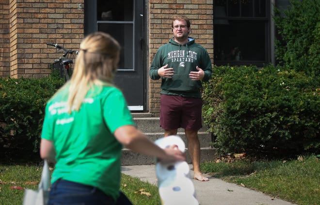 "You can just drop them on the sidewalk," MSU  senior Noah Terech says to Shipt delivery driver Anna Lindoff, Tuesday afternoon, Sept. 15, 2020.  Terech tested positive for  COVID-19 last week  and is quarantining in the house he shares with three other students on Grove Street in East Lansing.