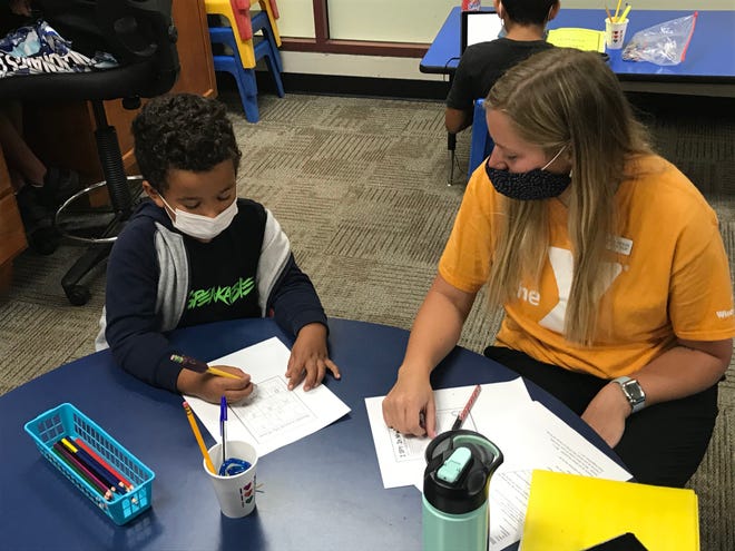 Site supervisor Brianna Mosley (right) works with first grader Ayden Edmondson (left) on an assignment at a Y Class held at the Southwest YMCA in Greenfield Sept. 10.