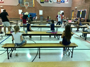 At Conley Elementary School in Chandler, students eat lunch one grade level at a time, two students to a table, all facing the same direction.