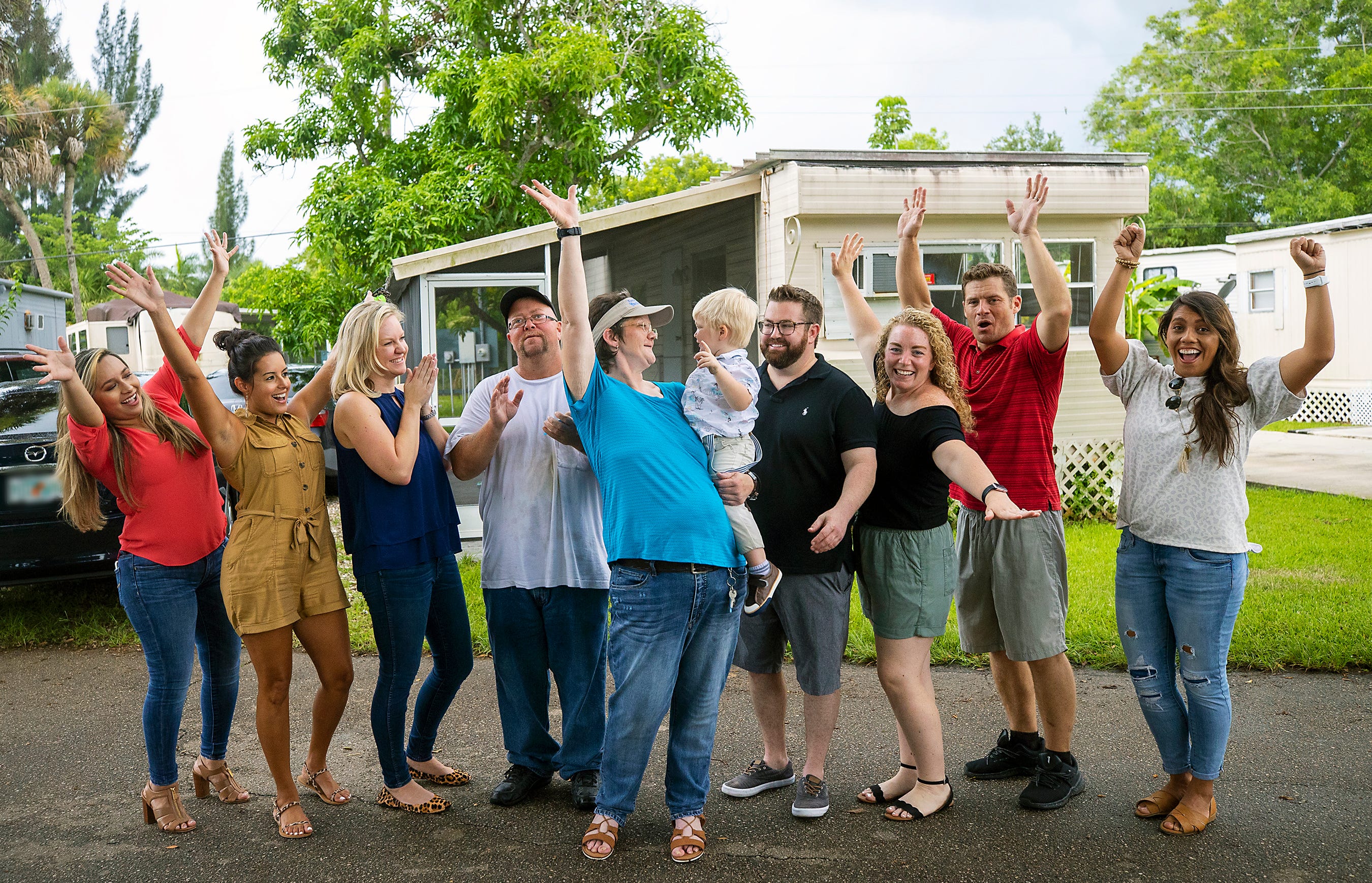 Kyrstal Hartman, center, and her toddler son Jack celebrated being reunited in their new home in July with members of Better Together and Jack’s father, Jason Davis, fourth from right.