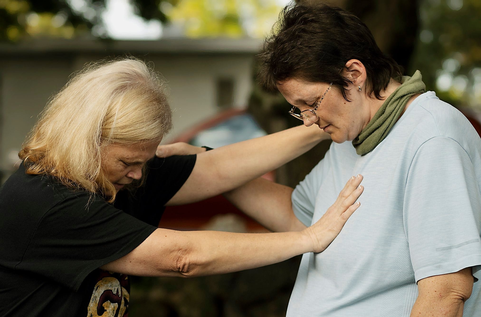 Two days before reunifying with her son, Jack, Kyrstal Hartman, right, prayed with friend, Cheryl Carbone, in July outside the transitional housing Kyrstal was living in at the time.