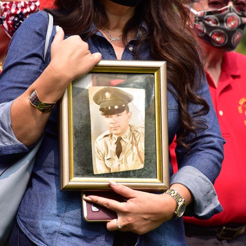 Susan Vella, of Monroe, holds a portrait of her fa