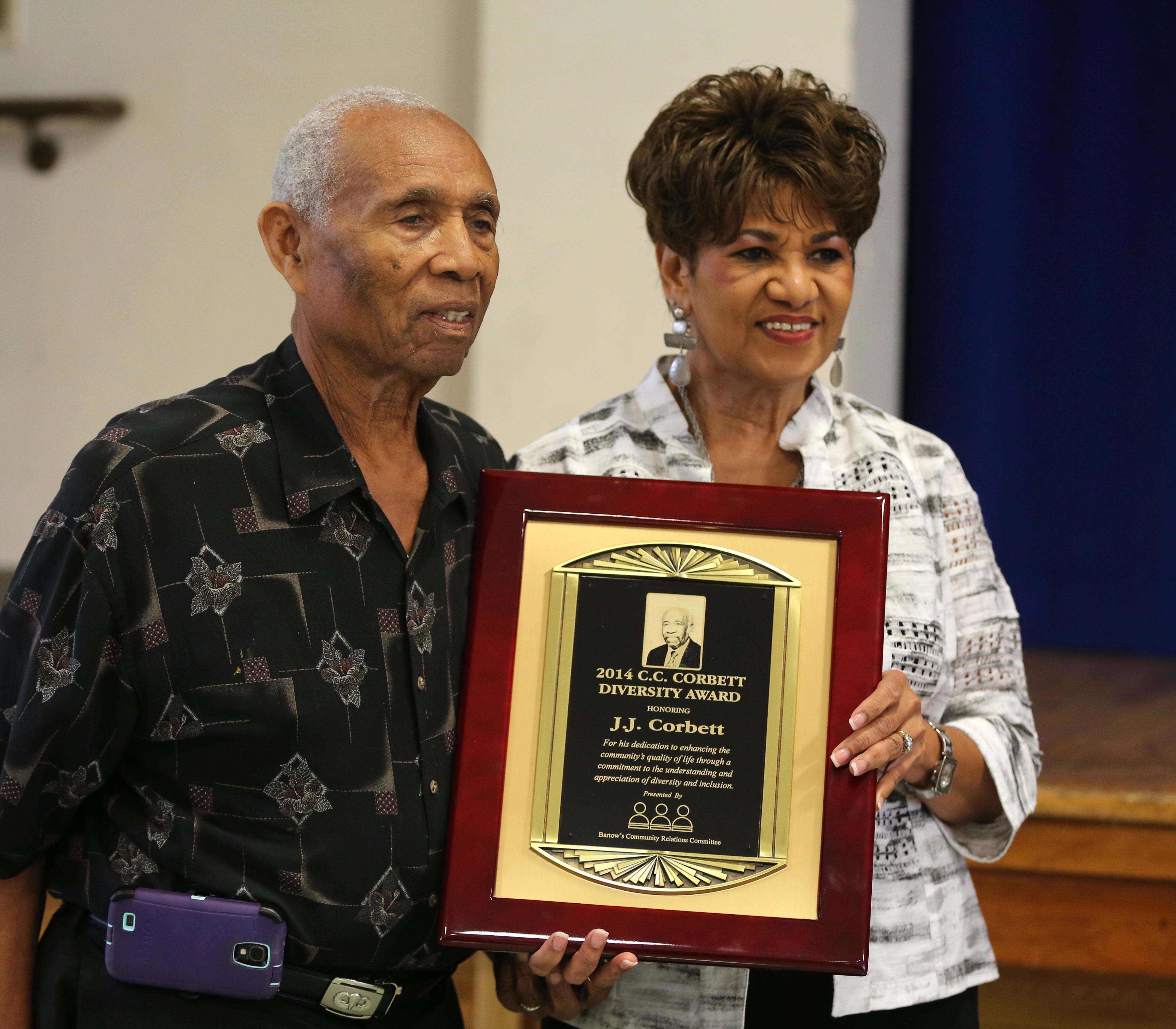J.J. Corbett, left, accepts the 2014 C.C. Corbett Diversity Award for an individual from 2013 winner Joyce Thurman during the Community Relations Committee Diversity Luncheon at the Bartow Civic Center on Sept. 17, 2014.