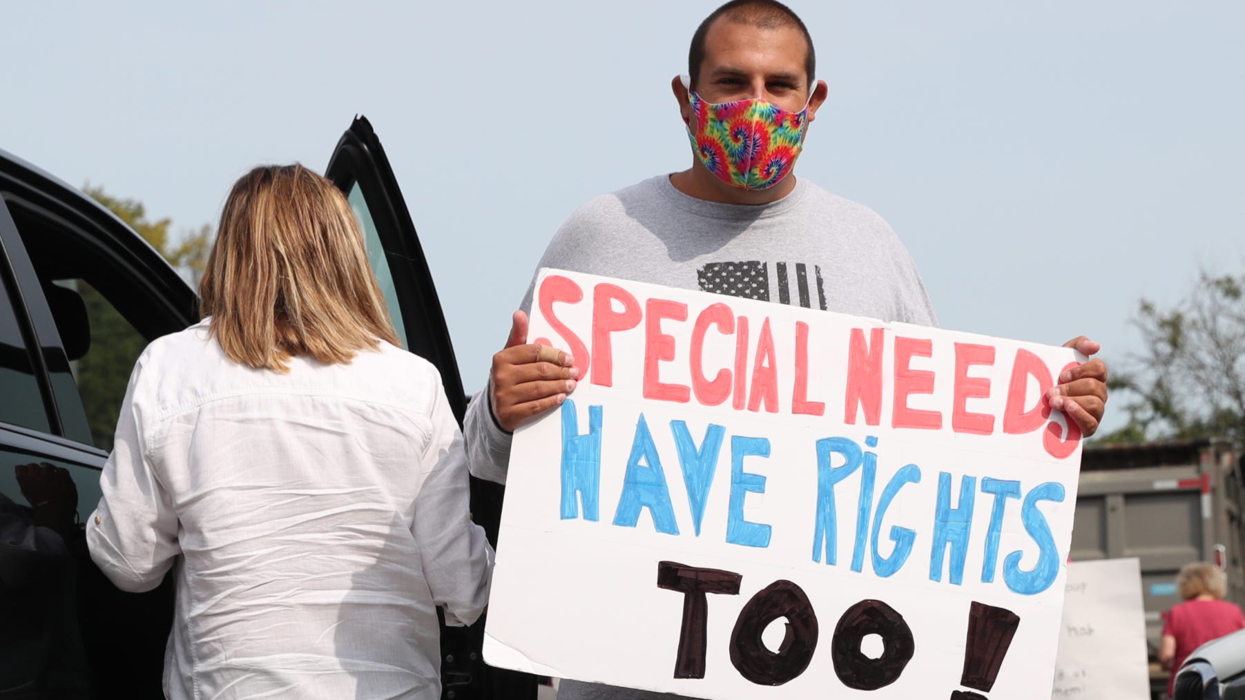 Nicholas Bonasera, 27, from Amity Harbor holds a sign as families from around the state gather for a caravan at the NYS Thruway rest area in Ardsley on Thursday, September 17, 2020, to protest the fiscal shape of group homes which face further state aid cuts to their funding.