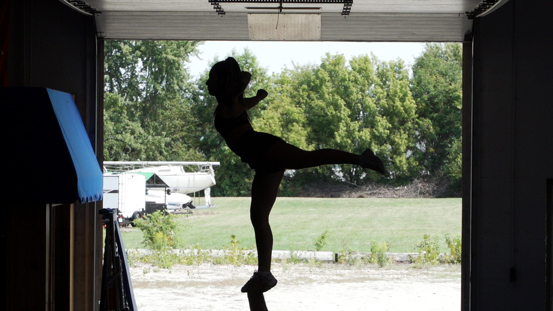 A cheerleader performs an arabesque.