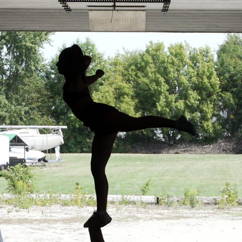 A cheerleader performs an arabesque.    