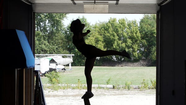A cheerleader performs an arabesque.    