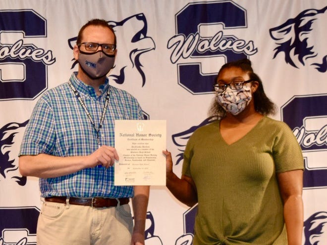 SHS Junior DeNiesha Barkus (right) receives her NHS certificate from Adviser Scott Bartley. More than 50 students were recently inducted into the school's NHS chapter.