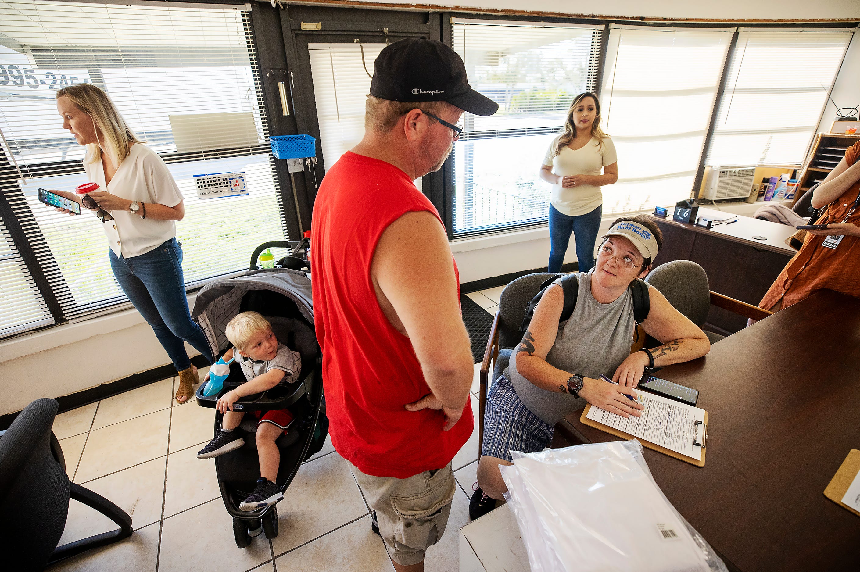 Jason Davis, center, and Kyrstal Hartman, third from left, applied to rent a mobile home in June. Megan Rose, left, and Gisela Estrada, rear right, of Better Together, helped Davis and Hartman.  