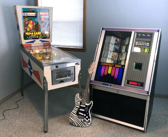 Three premium items from this year’s Roncalli Pierside Auction: a Pop*A*Card vintage pinball machine (from left); Paul McCartney’s zebra-striped, signed guitar that was played during his June 8, 2019, concert, at Lambeau Field; and a Rowe AMI Jukebox.