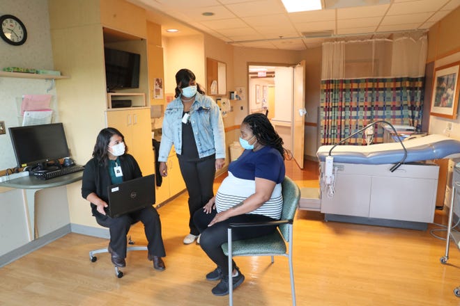 Diedra Gray of Milwaukee, a soon-to-be mom, talks to Nubia Rojas, left, a patient navigator and social worker, and Sharthedria Crawford, center, a patient navigator and community health worker, at the Women’s Outpatient Center-Ascension St. Joseph Hospital in Milwaukee. The pair make sure mothers have what they need to be successful parents after the baby is born as well as before.