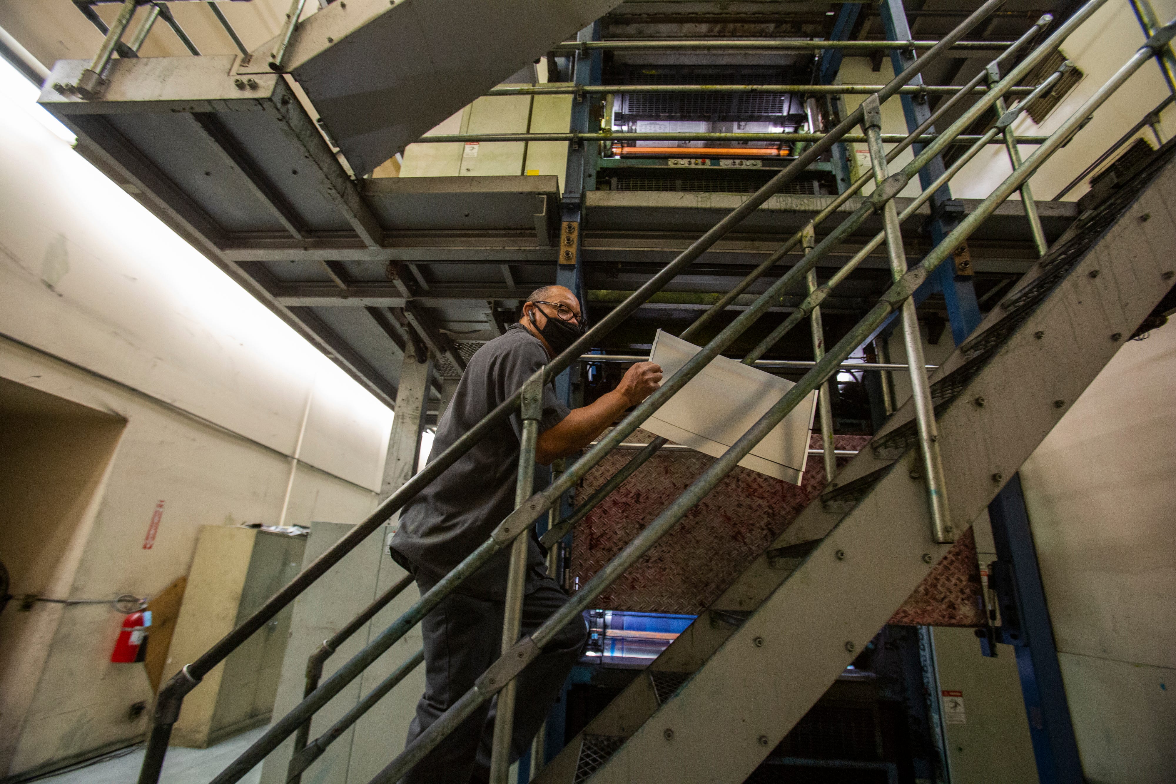 Wendell Saxton, senior press operator, walks up to set plates in the German presses used by the Desert Sun.