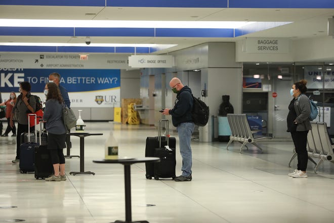 People wait in line spaced out to rent a car after arriving at Greater Rochester International Airport Friday, Sept. 18, 2020.