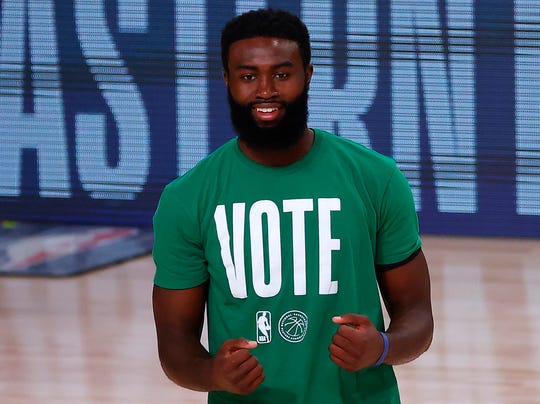 Celtics forward Jaylen Brown warms up in a VOTE shirt.