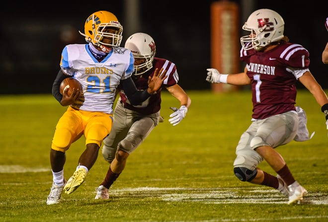 Central Hardin's KeAndre Johnson (21) is corralled by Henderson County's Seth (10) and Colton Evans (1) as the Henderson County Colonels host the Central Hardin Bruins at Henderson’s Colonel Stadium Friday evening, September 18, 2020.