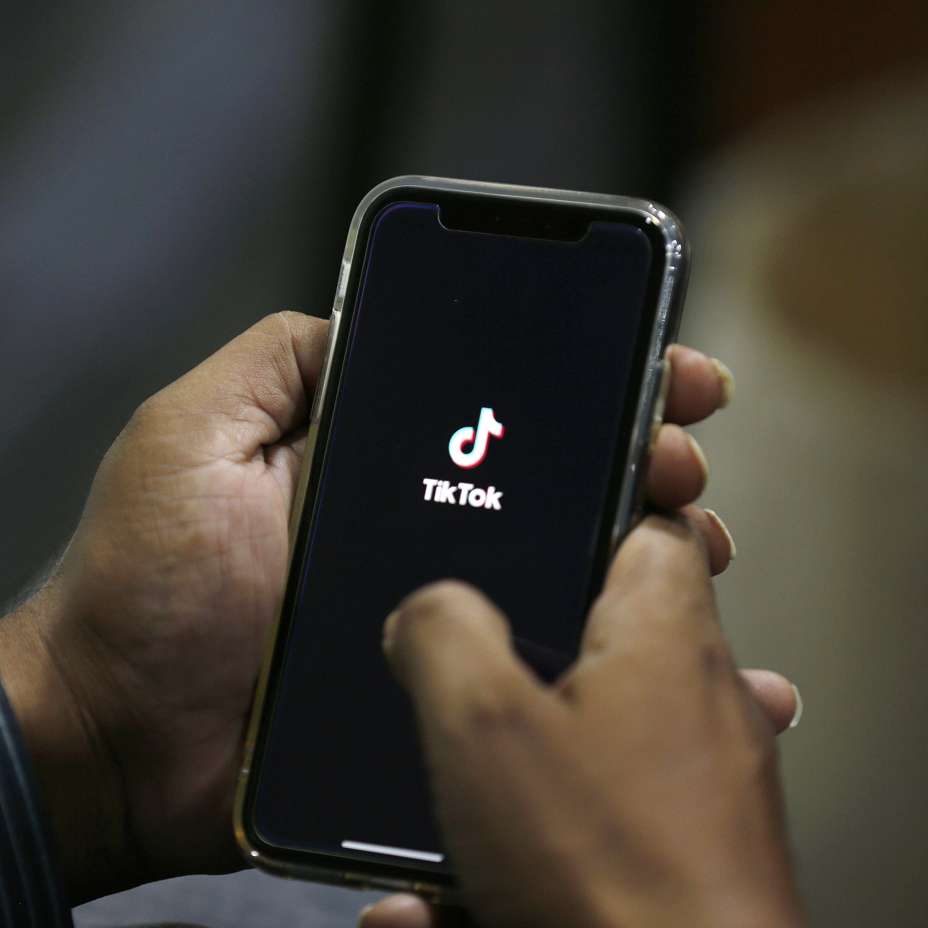 FILE - In this July 21, 2020 file photo, a man opens social media app 'TikTok' on his cell phone, in Islamabad, Pakistan. President Donald Trump said Saturday, Sept. 19, 2020 heâ€™s given his â€œblessingâ€ to a proposed deal between Oracle and Walmart for the U.S. operations of TikTok, the Chinese-owned app heâ€™s targeted for national security and data privacy concerns. (AP Photo/Anjum Naveed, File)