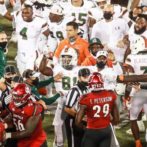 Miami players and Louisville players are separated
