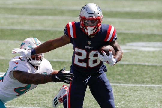 New England Patriots running back James White, a former Wisconsin Badger,  runs the ball against the Miami Dolphins at Gillette Stadium Sept. 13, 2020, in Foxborough, Mass. White learned his parents were in a traffic accident Sunday.