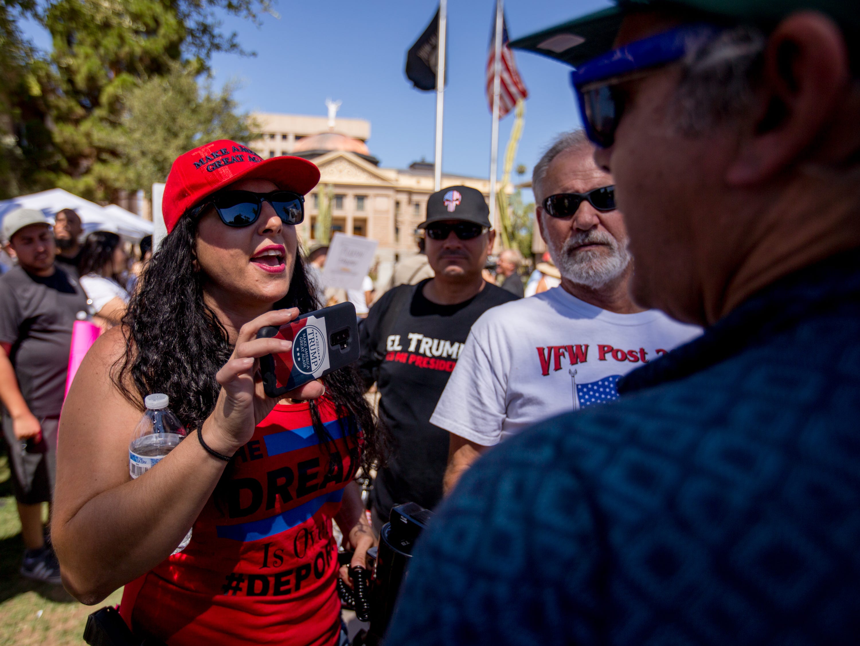 Jennifer Harrison, then of the Patriot Movement AZ group, yells "Trump is your president" through a megaphone on June 30, 2018, during the Families Belong Together rally outside of the Arizona state Capitol in Phoenix.