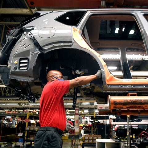 Nissan assembly line workers build 2021 Rogue vehi