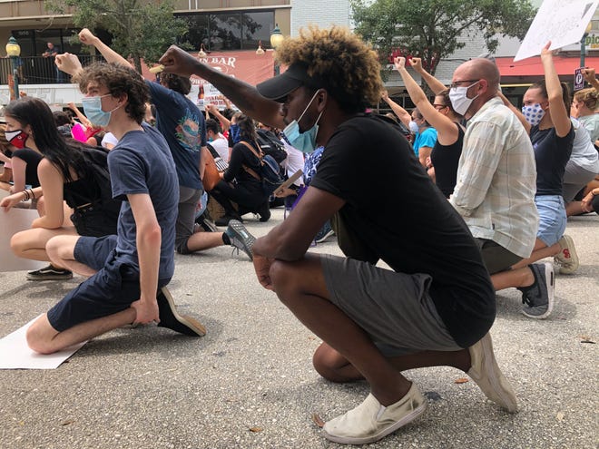 Protesters kneel in the middle of Main Street in downtown Sarasota during racial justice demonstrations in June 2020 in the wake of George Floyd’s death.