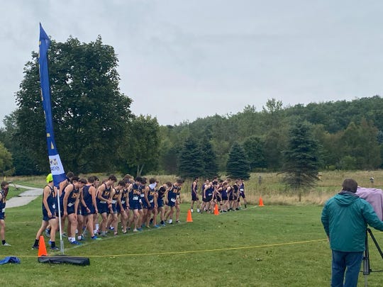 Members of the Kettle Moraine High School boys cross country team line up for the start of a cross country meet Sept. 12. They wrote messages on their race bibs to show unity after an incident in which two students at their school wrote a racially insensitive social media post to another student.