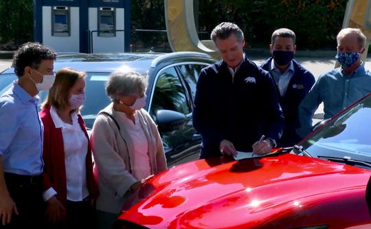 Gov. Gavin Newsom signs an executive order concerning electric vehicles on Sept. 23, 2020.
