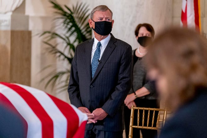 Chief Justice of the United States John Roberts, center, and Associate Justice Elena Kagan, right, watch as the flag-draped casket of Justice Ruth Bader Ginsburg arrives at the Supreme Court in Washington, Wednesday, Sept. 23, 2020.
