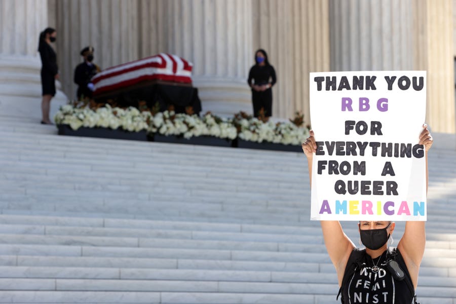 A woman salutes Associate Justice Ruth Bader Ginsburg, whose flag-draped casket rests on the Lincoln Catafalque outside the U.S. Supreme Court on Sept. 23 in Washington. Ginsburg died Sept. 18 at the age of 87 after a long battle against cancer.