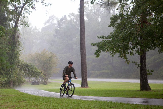 A bike rider travels along a trail in light rain ahead of Hurricane Dorian at Marine Corps Base Camp Lejeune in September 2019.