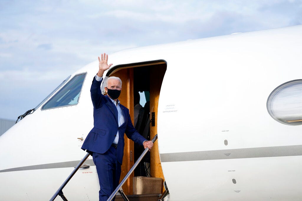 Democratic presidential candidate Joe Biden waves as he boards a plane at Charlotte Douglas International Airport in Charlotte, N.C., following his campaign stop to that city on Sept. 23, 2020,.