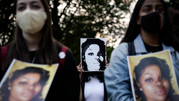 Demonstrators hold up images of Breonna Taylor as 