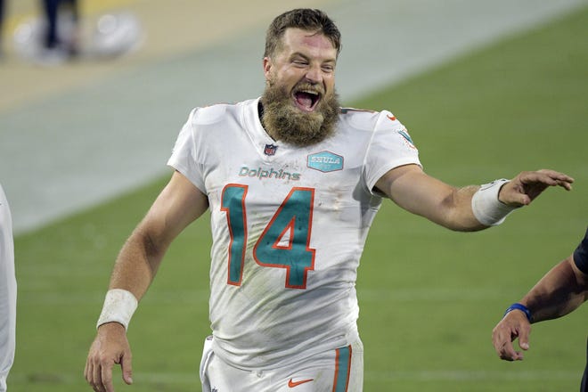 Dolphins quarterback Ryan Fitzpatrick laughs with coaches as he comes off the field after defeating the Jacksonville Jaguars.