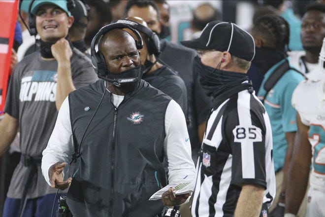 Miami Dolphins head coach Brian Flores, left, has a discussion with line judge Daniel Galllager (85) during the second half of an NFL football game, Thursday, Sept. 24, 2020, in Jacksonville, Fla. (AP Photo/Stephen B. Morton)